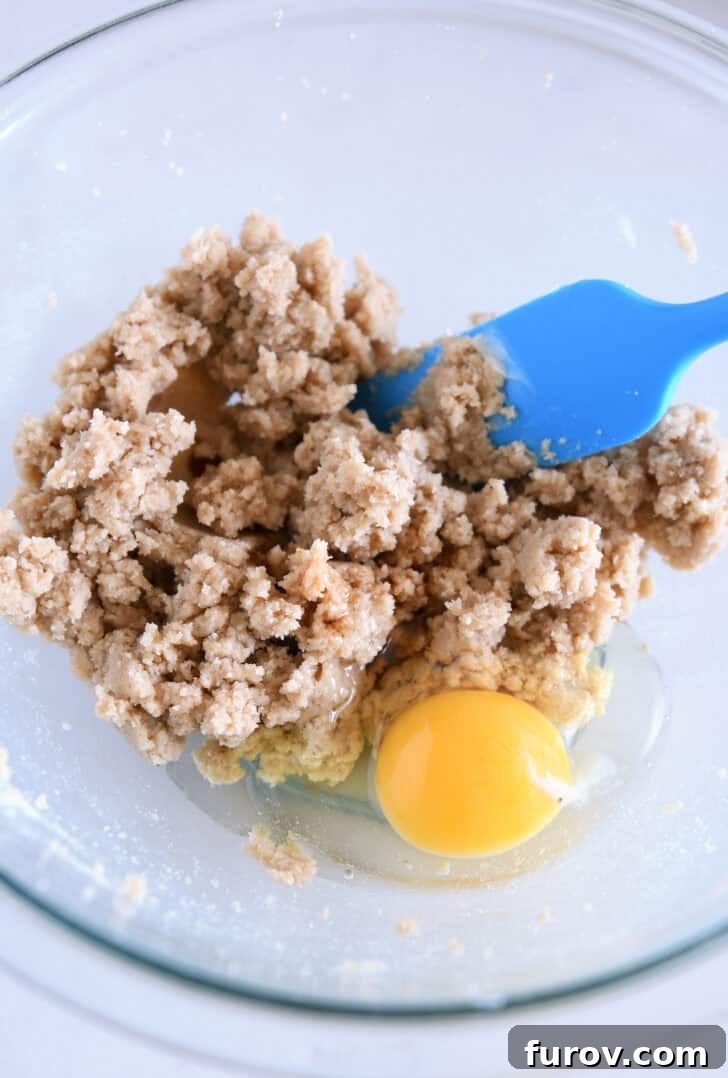 A glass bowl with sugar and melted butter being creamed together.