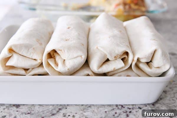 White baking pan with rolled freezer breakfast burritos.