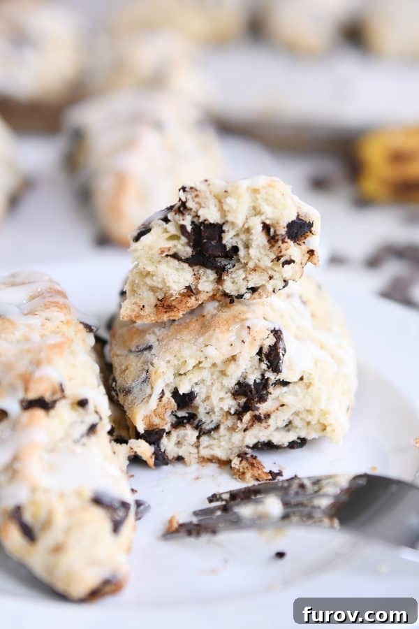 Decadent Chocolate Chip Banana Bread Scones 3 Banana bread scone broken in half on white plate.