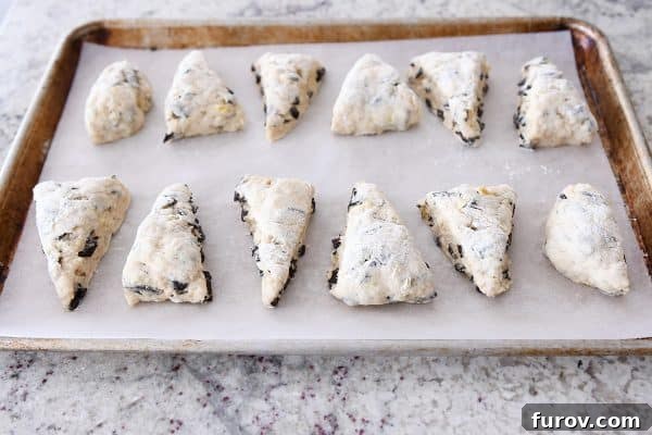 Decadent Chocolate Chip Banana Bread Scones 8 Scone triangles on parchment lined baking sheet.