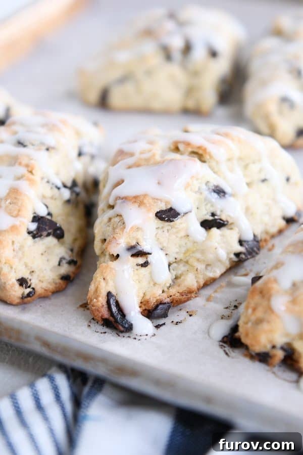 Decadent Chocolate Chip Banana Bread Scones 9 Several chocolate chip banana bread scones on baking sheet.