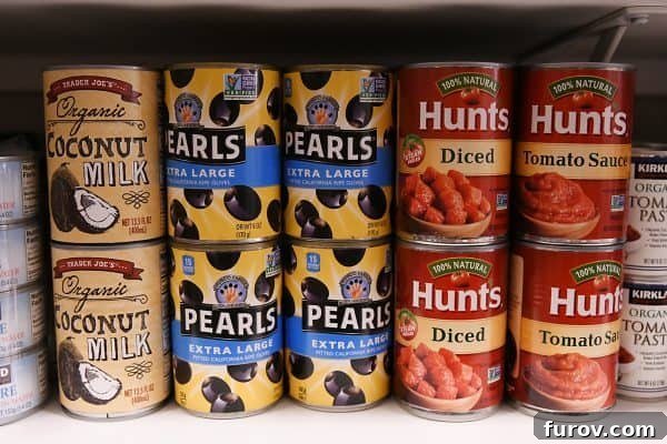 olives and coconut milk and diced tomatoes on pantry shelf
