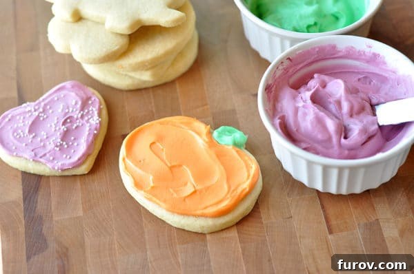 Forgotten Feasts A Culinary Revival 2 Delightful frosted heart and pumpkin sugar cookies, alongside ramekins of pink and green frosting and a stack of unfrosted sugar cookies, all beautifully arranged on a rustic brown table.