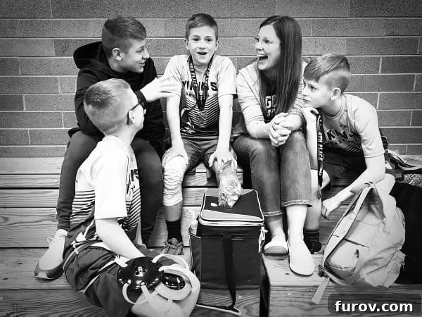 Mother sitting in bleachers engaging in thoughtful conversation with her kids, depicting a moment of connection and guidance