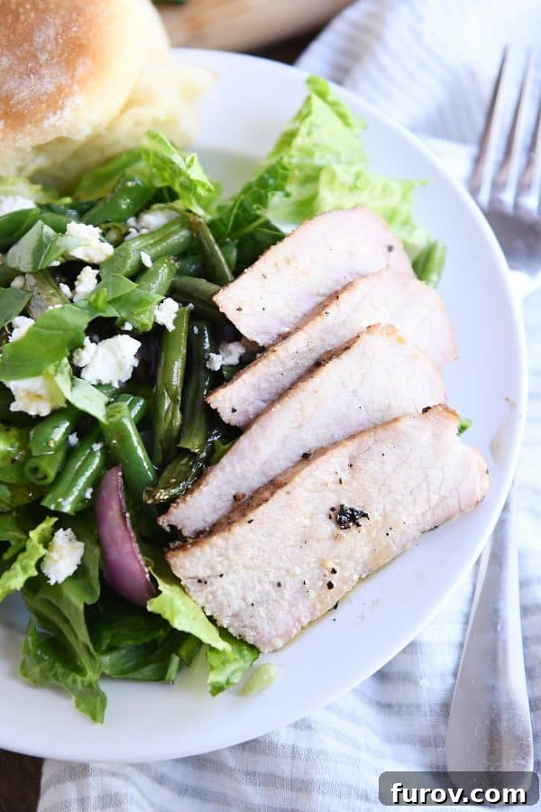 Close-up of perfectly grilled, thinly sliced pork chops displaying a beautiful char and tender texture.