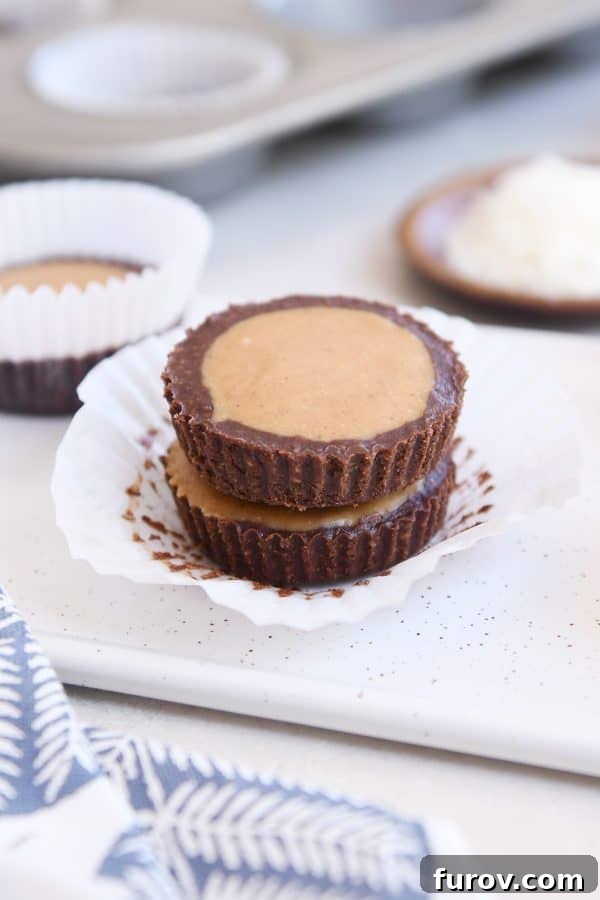 Irresistible No-Bake Peanut Butter Cups: Vegan, Gluten-Free Indulgence 2 Two unwrapped no-bake peanut butter cups stacked on top of each other, showcasing their distinct chocolate and peanut butter layers.