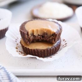 Two unwrapped no-bake peanut butter cups stacked with bite taken out of top peanut butter cup