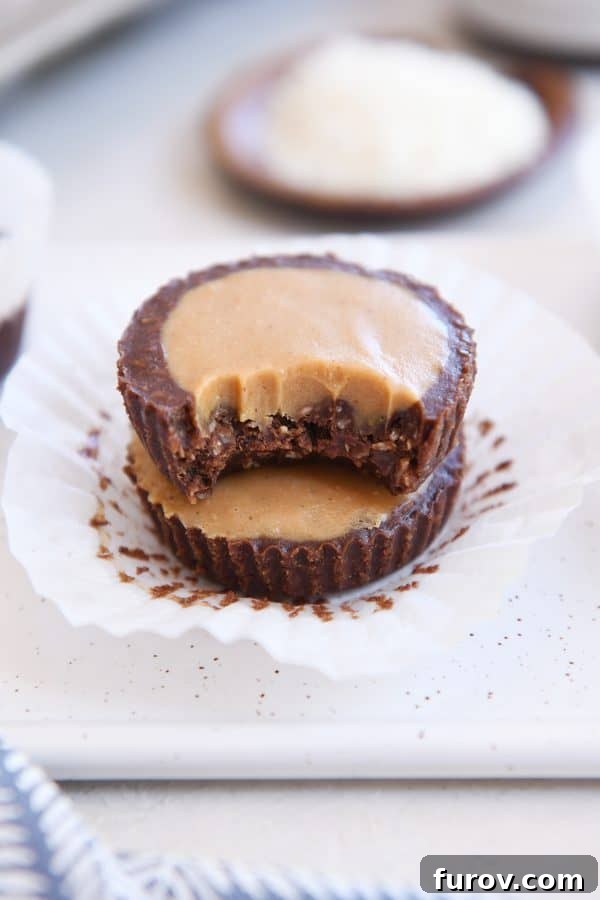 Irresistible No-Bake Peanut Butter Cups: Vegan, Gluten-Free Indulgence 3 A stacked pair of unwrapped no-bake peanut butter cups, with a bite taken from the top cup to reveal the smooth peanut butter filling.