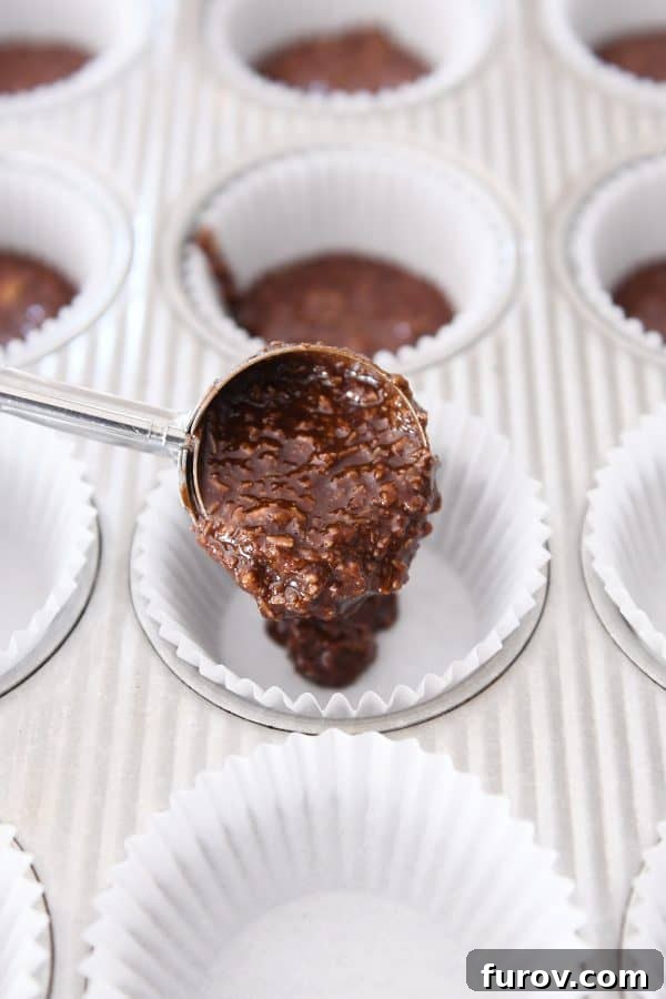 Irresistible No-Bake Peanut Butter Cups: Vegan, Gluten-Free Indulgence 6 A hand scooping the no-bake chocolate mixture into a muffin liner, demonstrating the easy assembly process.