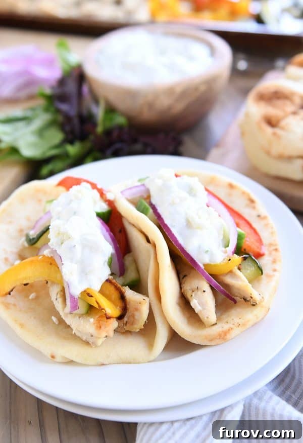 Two vibrant sheet pan chicken tzatziki wraps perfectly arranged on a white plate, ready to be enjoyed.