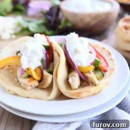 Two sheet pan chicken tzatziki wraps on a white plate, showcasing the finished meal.
