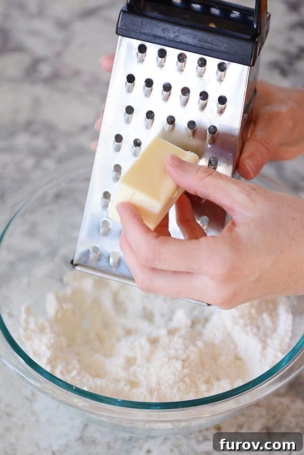 Unlock the Secret to Flaky Homemade Pie Crust 8 Frozen butter being grated into a bowl of flour and shortening mixture.