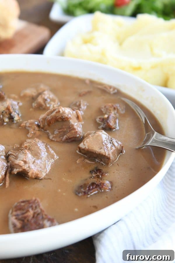 Fall-Apart Tender Slow Cooker Beef in Rich Gravy 3 Serving bowl filled with rich beef tips and gravy, ready for the table.