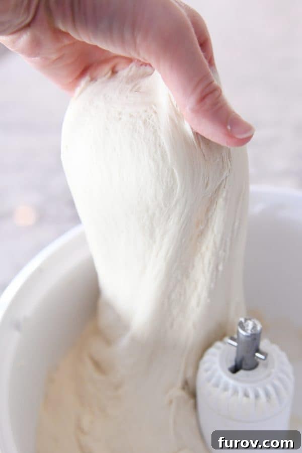 Sourdough for the Unmotivated 15 Pulling up bread dough out of mixer with hand.