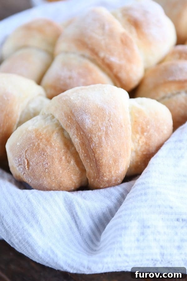 Basket filled with perfectly golden, fluffy crescent rolls, ready to be served.