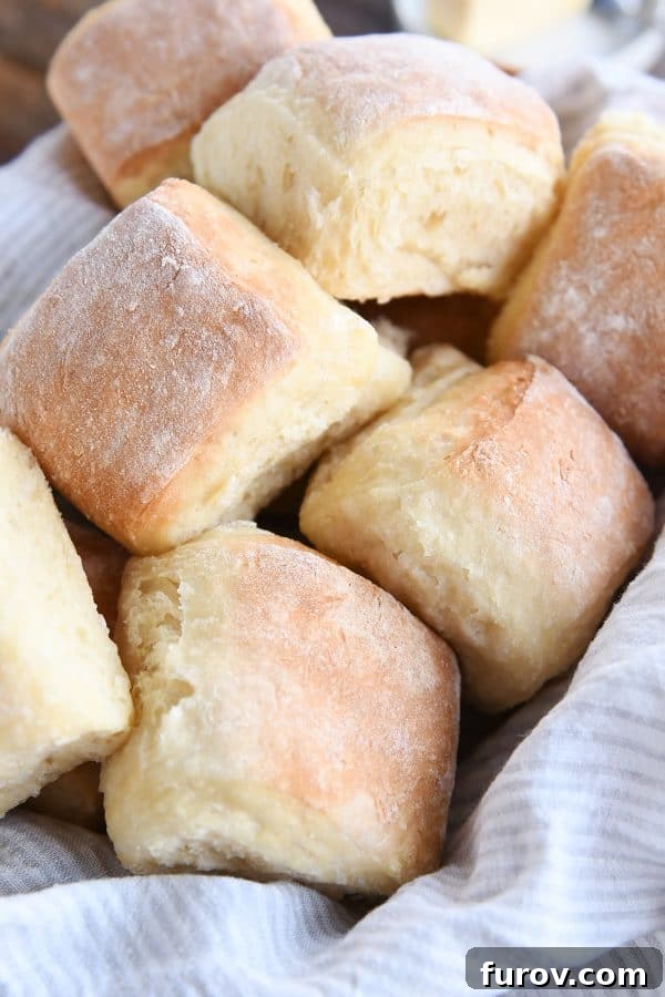 A warm, inviting pile of easy fluffy blender rolls nestled in a basket with a patterned napkin, ready to be enjoyed.