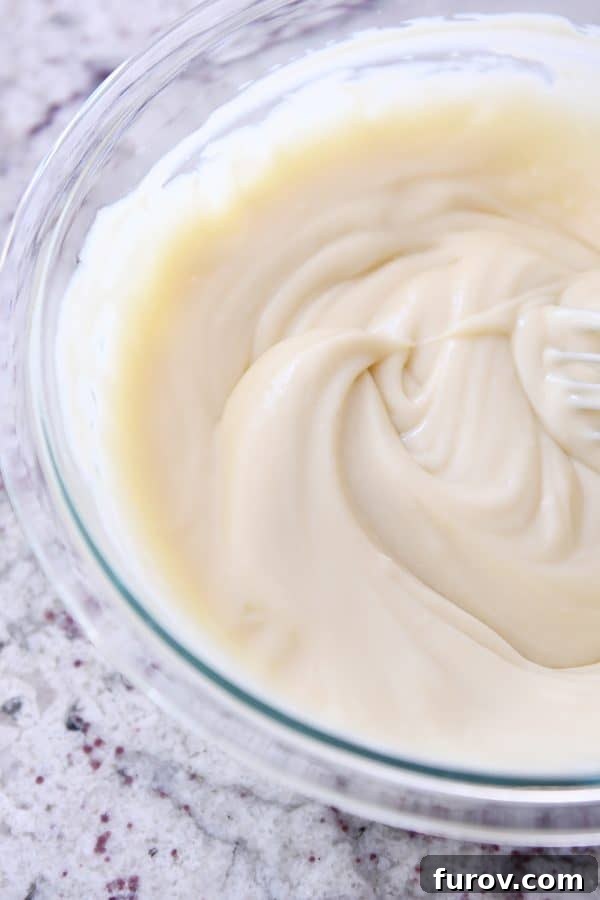 A glistening glass bowl filled with freshly made homemade vanilla pudding, ready for pie filling.