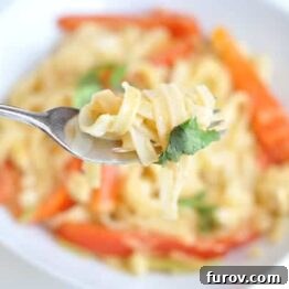 A small, mouth-watering image of Red Coconut Curry Noodles in a bowl, highlighting the vibrant colors and creamy sauce.