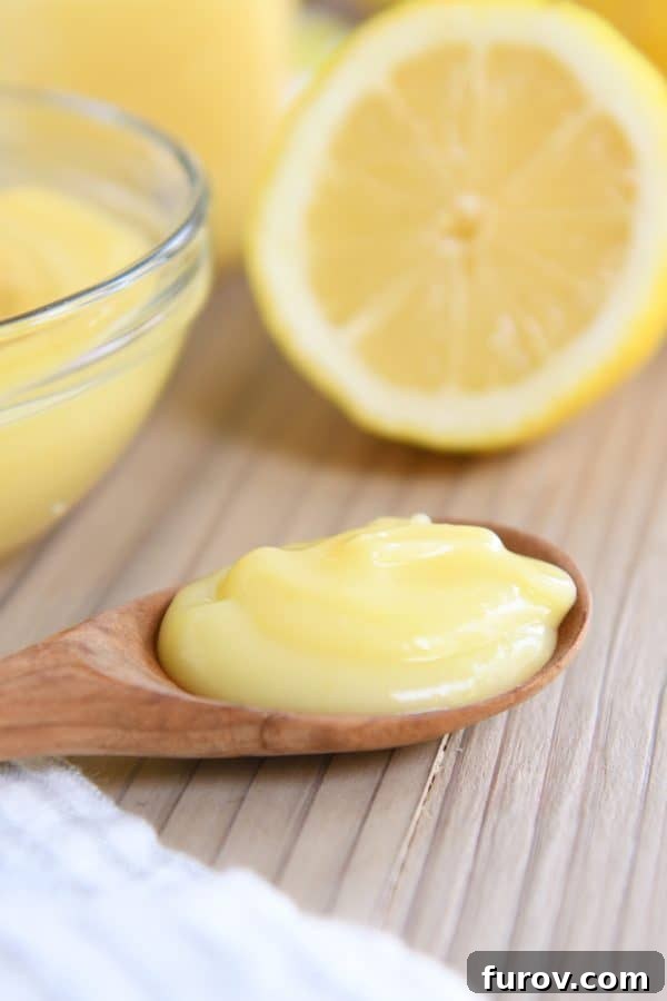 Bright and Zesty Instant Pot Lemon Curd 4 A wooden spoon delicately holding a spoonful of golden lemon curd, resting on a wooden cutting board.
