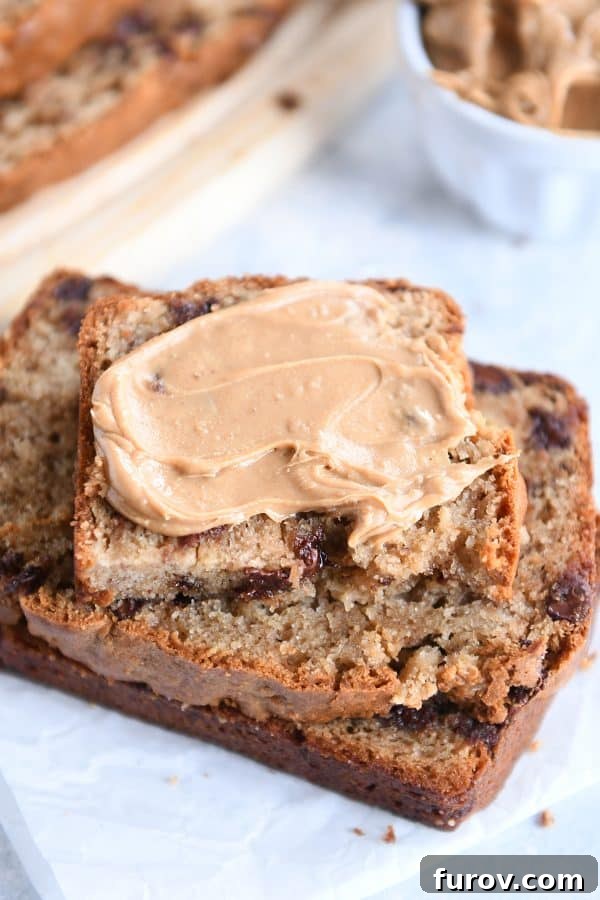 Stack of peanut butter banana bread slices with peanut butter spread on top.