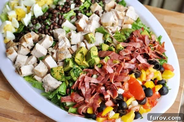 Fiesta Cobb with Bright Green Goddess Dressing 2 A beautifully arranged chopped Southwestern Cobb Salad on a white platter, showcasing fresh romaine, chicken, and colorful vegetables.