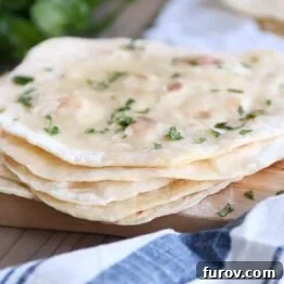 stack of easy yogurt flatbread on wood cutting board sprinkled with parsley