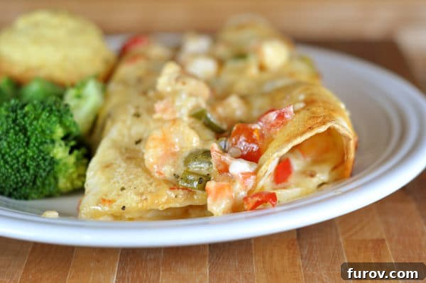 Velvet Shrimp Enchiladas Blanco 6 Two perfectly baked shrimp enchiladas, topped with melted cheese and ready to enjoy, on a clean white plate.