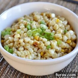 A close-up image of a vibrant grilled corn salad with green onions, showcasing its fresh appeal.