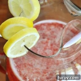 A vibrant pitcher of homemade fresh strawberry lemonade.