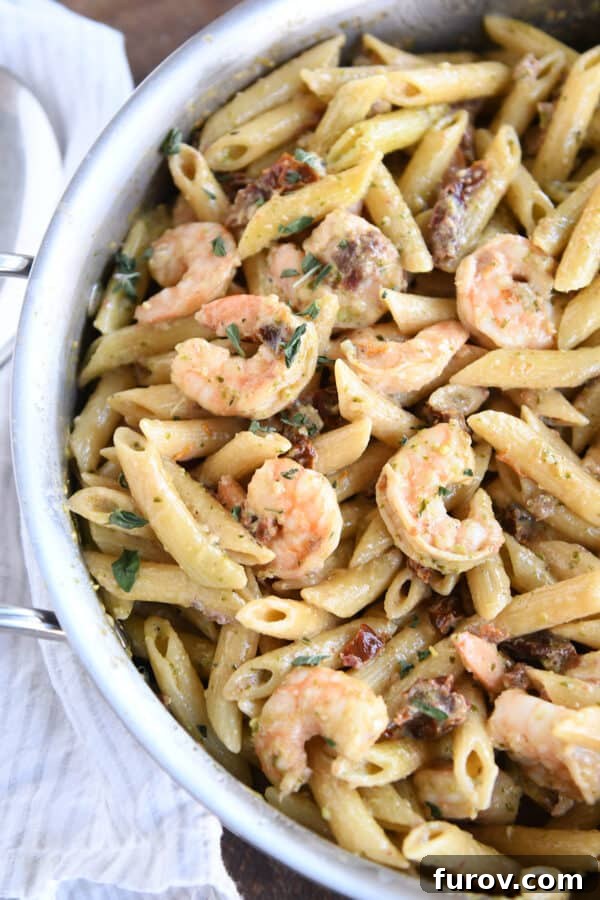 Vibrant Pesto Shrimp Pasta with Sun Kissed Tomatoes 6 Top-down view of easy shrimp pesto pasta in a skillet, ready to be served.