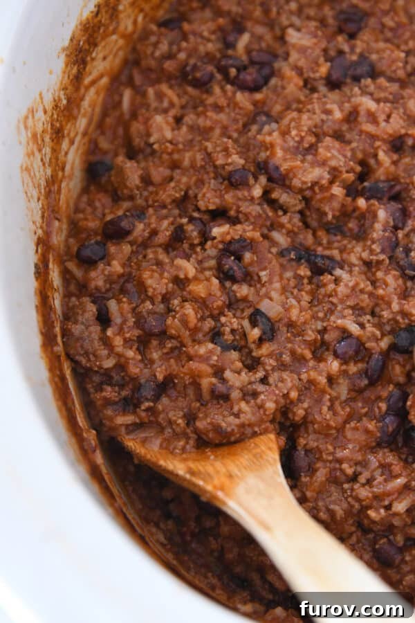 Elevated Taco Bowls with Zesty Creamy Lime Dressing Stovetop or Slow Cooker 5 A slow cooker brimming with the hearty taco meat and rice mixture, simmering to perfection, ready to be the star of Floating Taco Bowls.