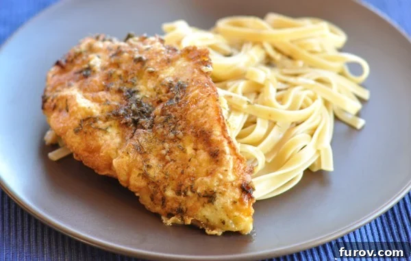 Close-up of golden-brown breaded chicken pieces alongside cooked pasta, all ready to be served on a brown plate.