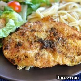 Close-up of golden-brown breaded chicken in a lemon-butter sauce.
