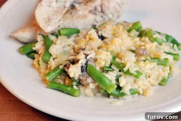 Creamy Cheesy Chicken and Rice Skillet with Green Beans 2 A close-up shot of creamy white rice and vibrant green beans, served alongside perfectly sliced, browned chicken breast.