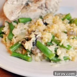 A smaller plate showcasing creamy white rice and green beans, with sliced chicken on the side.