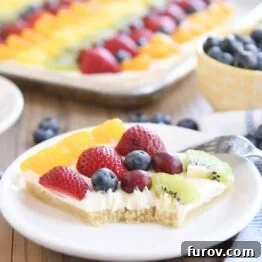 square of the best fruit pizza with bite taken out on white plate