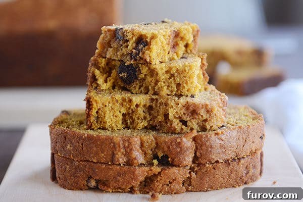 Thick slices and pieces of pumpkin chocolate chip bread stacked on top of each other. 