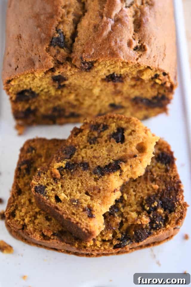 Half slice of pumpkin bread on top of two full slices on white platter.