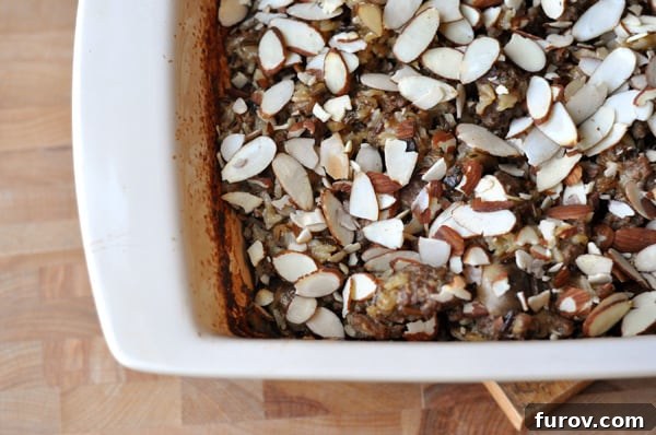 A beautifully presented Wild Rice Hot Dish in a white casserole dish, generously topped with golden sliced almonds.