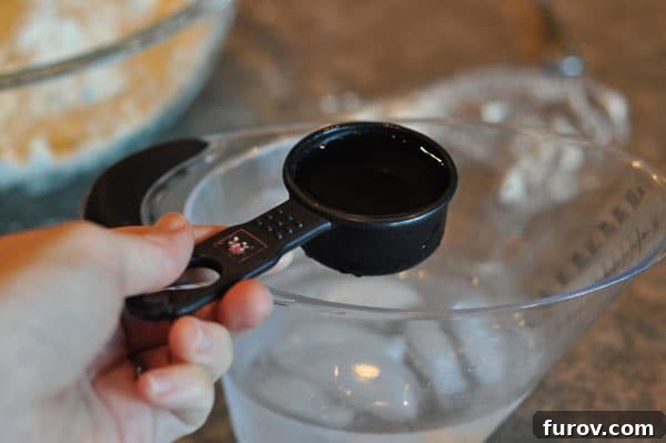black measuring cup with ice water, precisely measured.