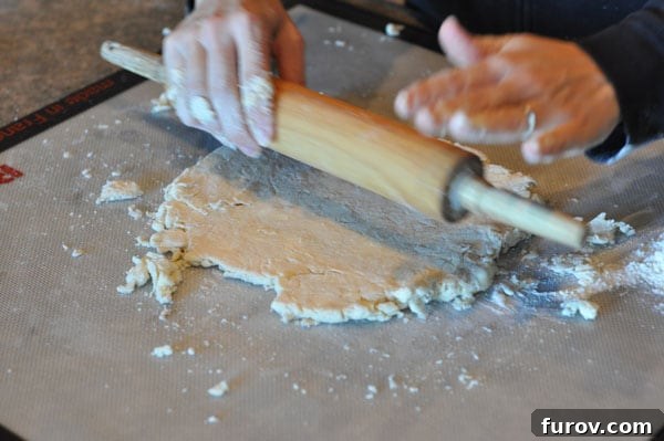 pie crust being rolled out with a rolling pin, showing smoother texture.