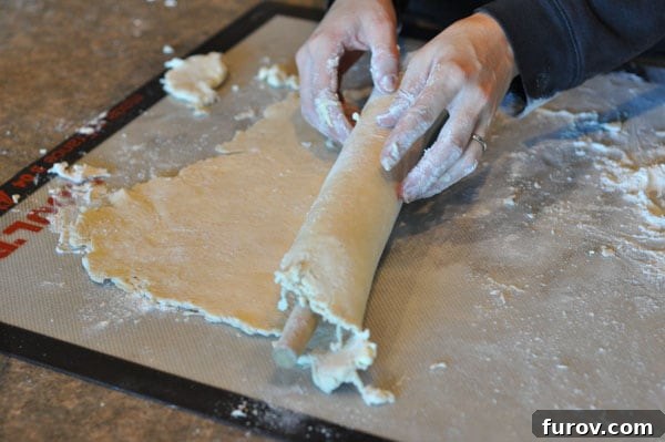 rolling up a pie crust over a rolling pin, gentle handling.