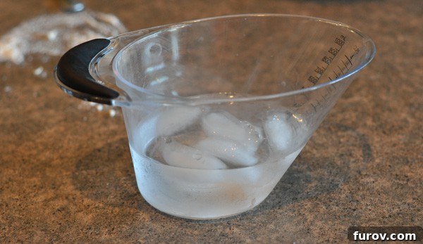 clear measuring cup with ice water, prepared for pie crust.