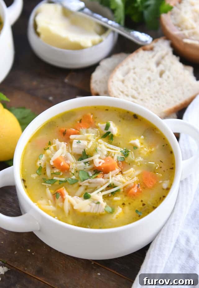 Sunshine Lemon Chicken Orzo Soup 2 A comforting bowl of Lemon Chicken Orzo Soup, garnished with fresh herbs, served alongside crusty bread and butter.