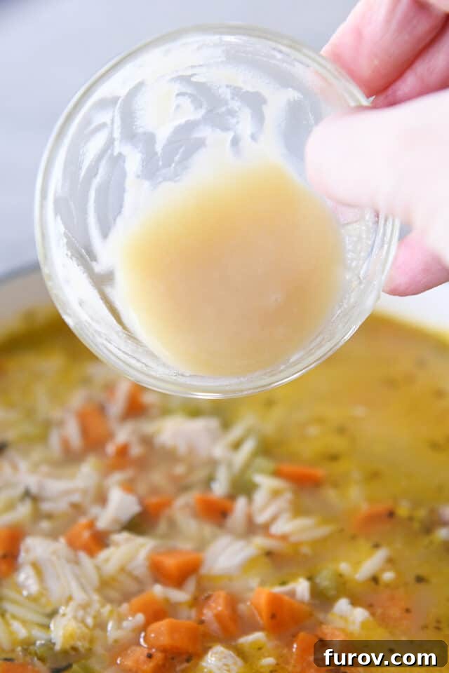 Sunshine Lemon Chicken Orzo Soup 6 A simple butter and flour roux being whisked into a pot of lemon chicken orzo soup, enhancing its texture and richness.