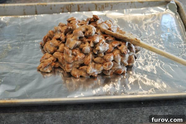A mound of candy-coated almonds piled onto a tinfoil-lined cookie sheet, awaiting distribution.
