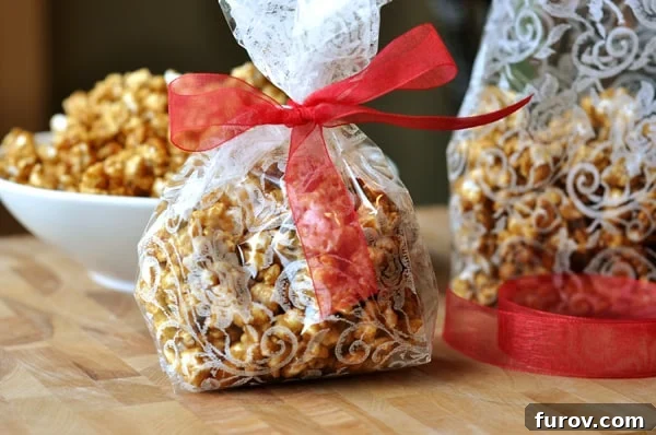 Decorative plastic bags filled with golden butter toffee popcorn and tied with festive red ribbons, perfect for gifting.