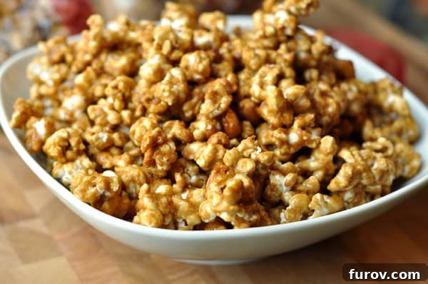 A crisp white bowl overflowing with freshly made butter toffee popcorn, ready to be enjoyed.