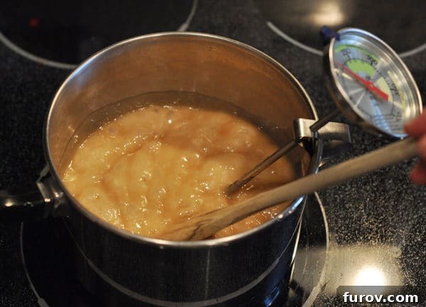 A saucepan on the stove contains a golden brown, bubbling butter and sugar mixture, transforming into delicious toffee.