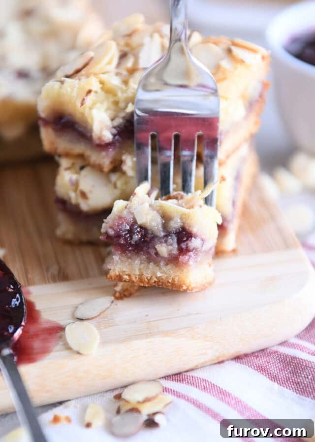 Luscious Raspberry White Chocolate Blondies 3 Fork scooping off corner of raspberry white chocolate blondie bar.